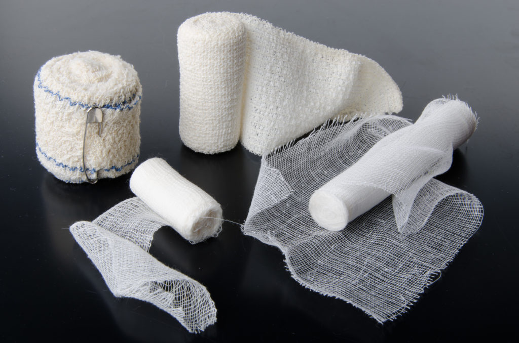 Different rolls of medical bandages on a black background
