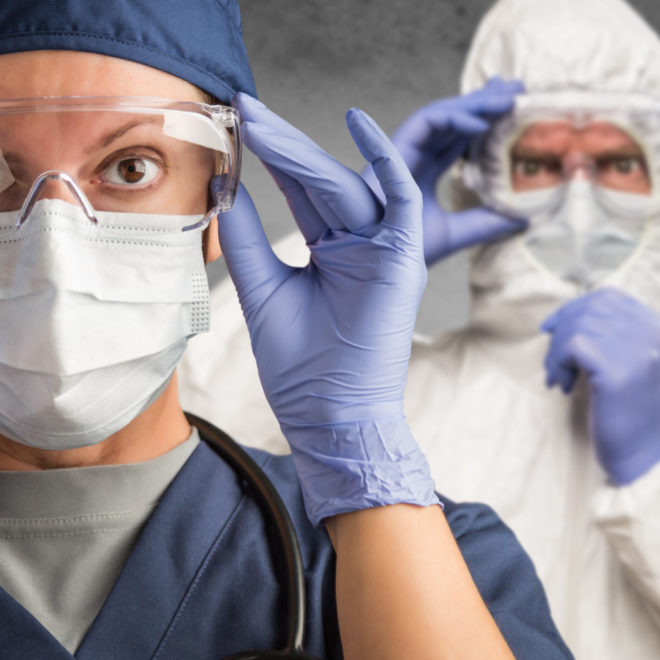 La photo montre deux personnes équipées de blouses et masques de protection contre le coronavirus