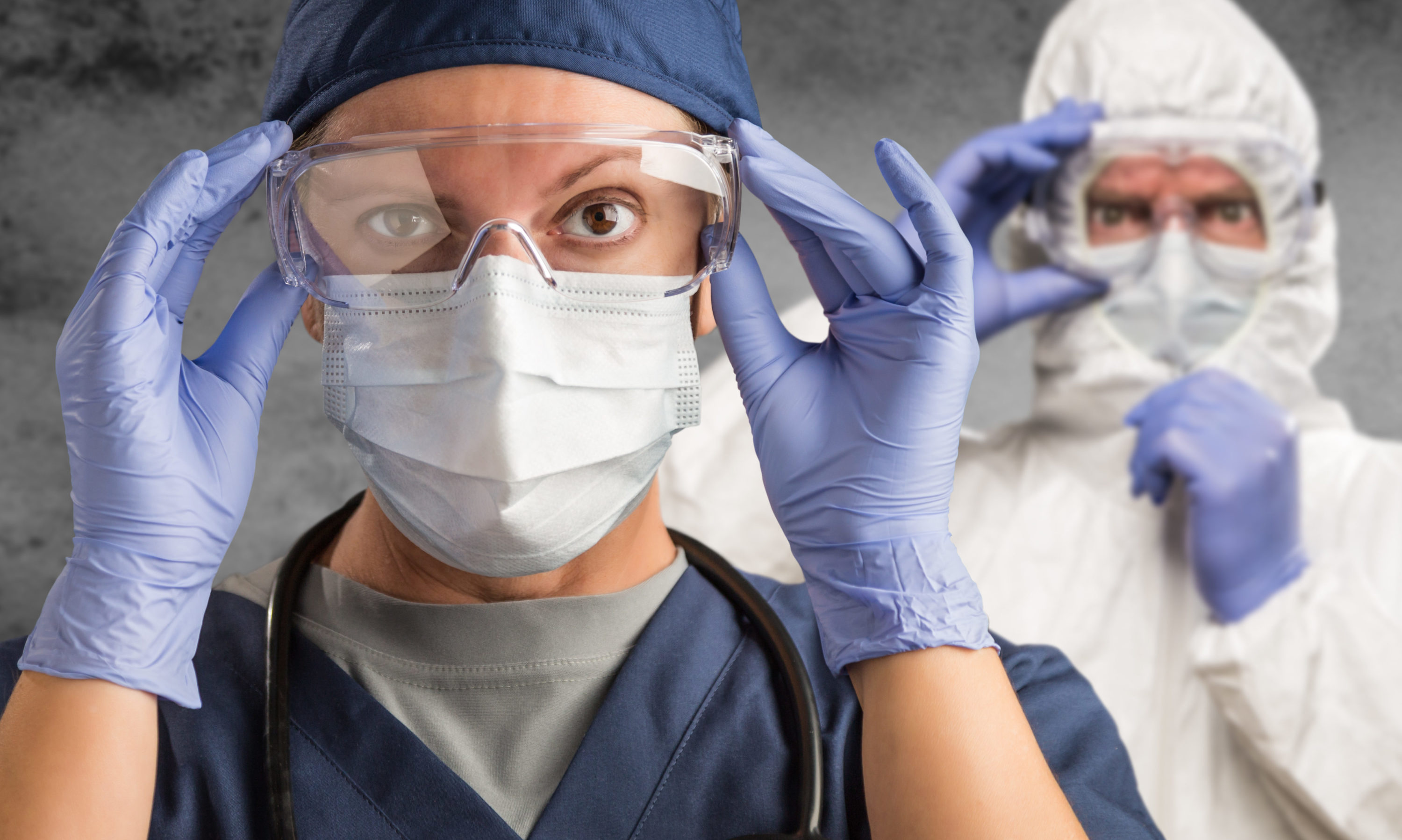 La photo montre deux personnes équipées de blouses et masques de protection contre le coronavirus